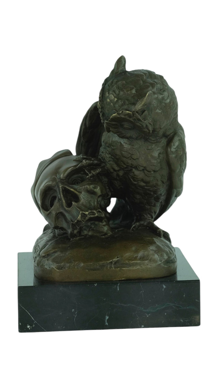 Bronze sculpture of an owl sitting next to a crowned skull