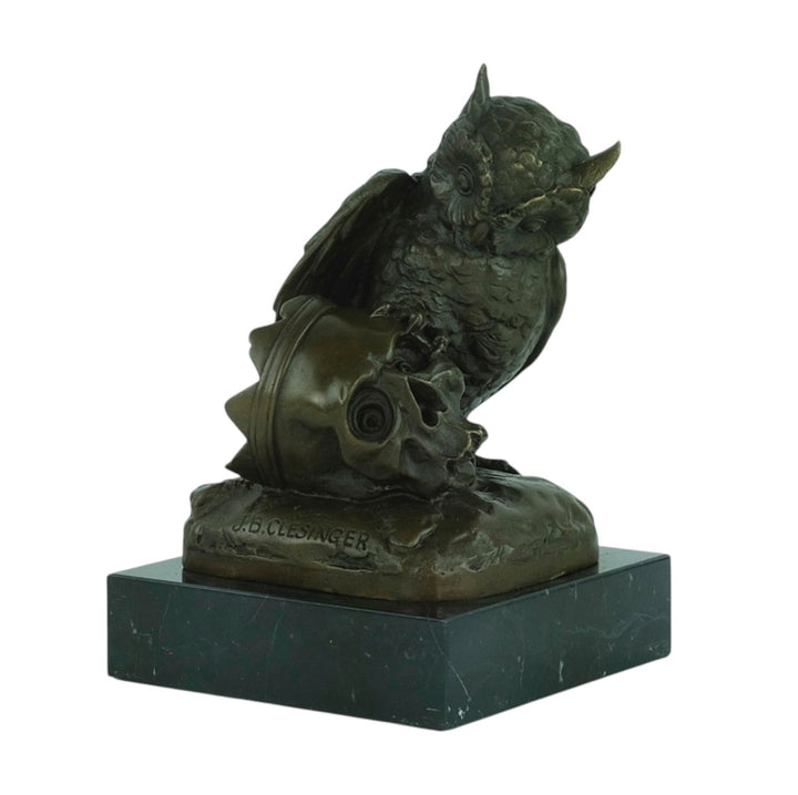 Bronze sculpture of an owl sitting next to a crowned skull