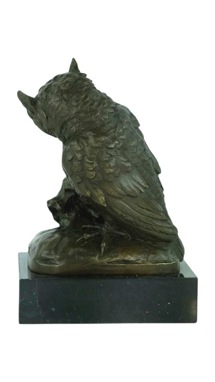 Bronze sculpture of an owl sitting next to a crowned skull