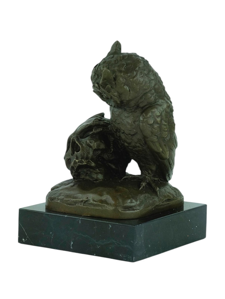 Bronze sculpture of an owl sitting next to a crowned skull
