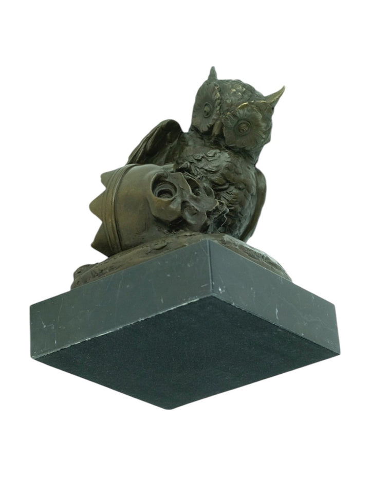 Bronze sculpture of an owl sitting next to a crowned skull