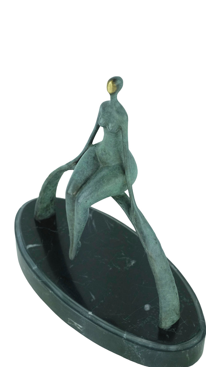 Modern bronze sculpture of a female sitting on a bow