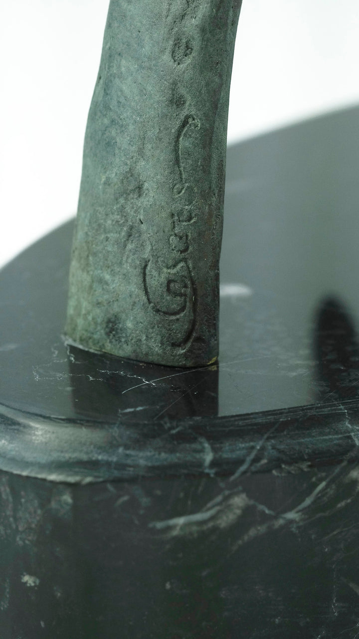 Modern bronze sculpture of a female sitting on a bow