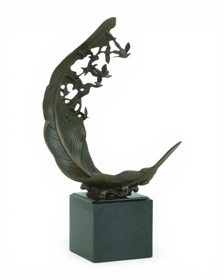Escultura de bronce de palomas volando de una pluma