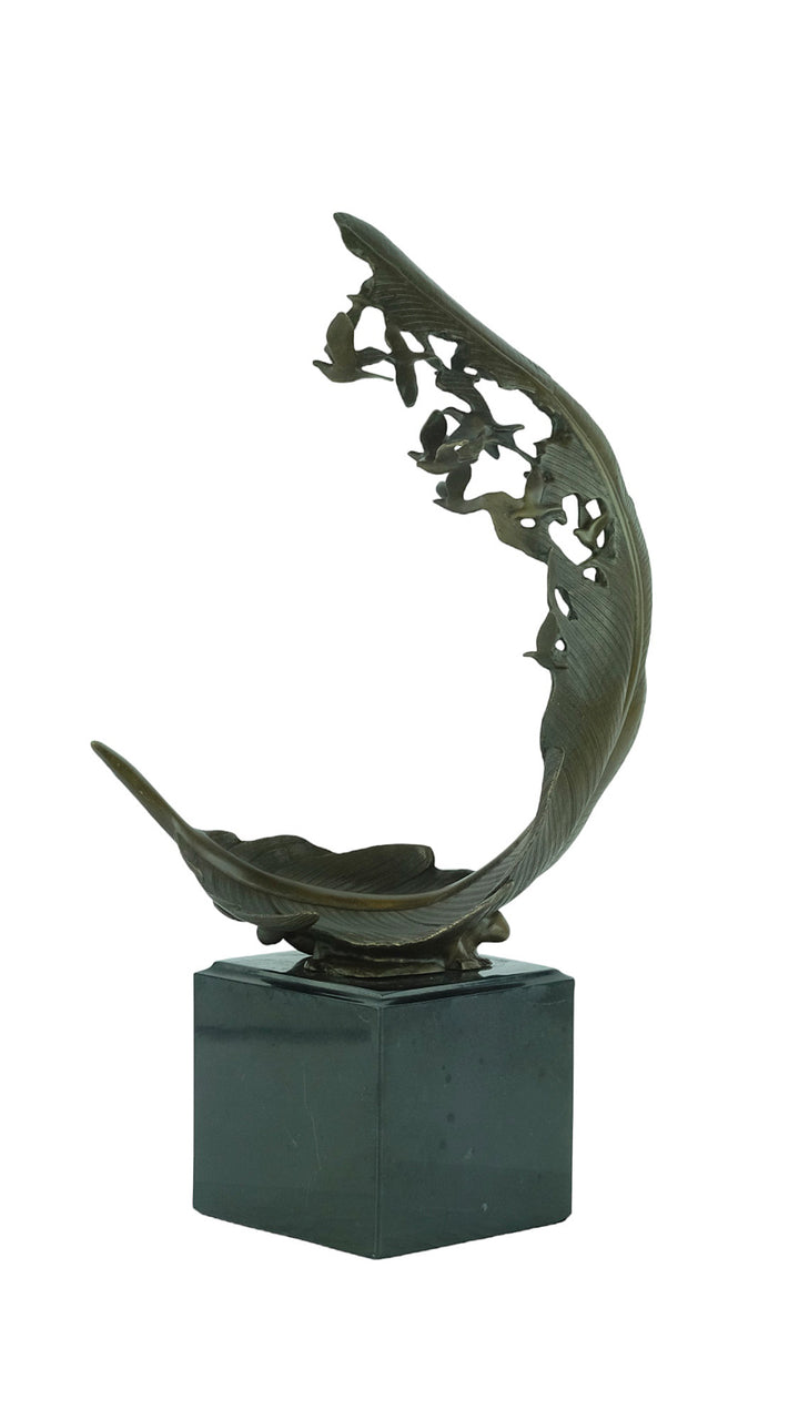 Bronze sculpture of doves flying out of a feather