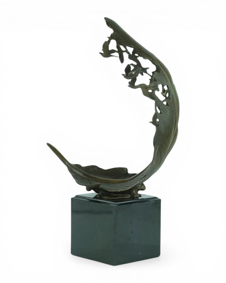 Escultura de bronce de palomas volando de una pluma