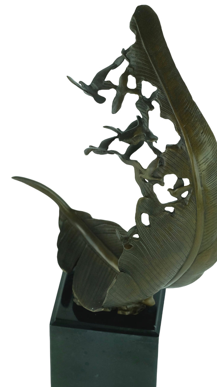 Bronze sculpture of doves flying out of a feather