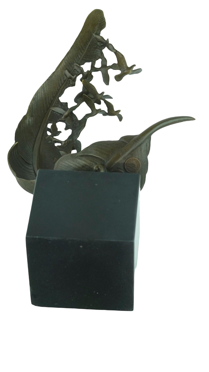 Bronze sculpture of doves flying out of a feather