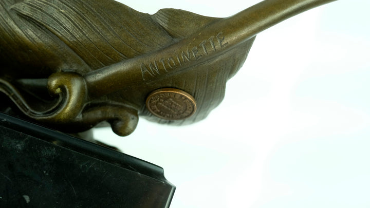 Bronze sculpture of doves flying out of a feather