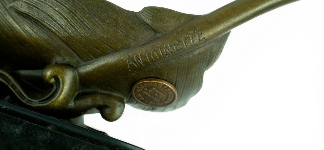 Escultura de bronce de palomas volando de una pluma