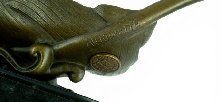 Escultura de bronce de palomas volando de una pluma