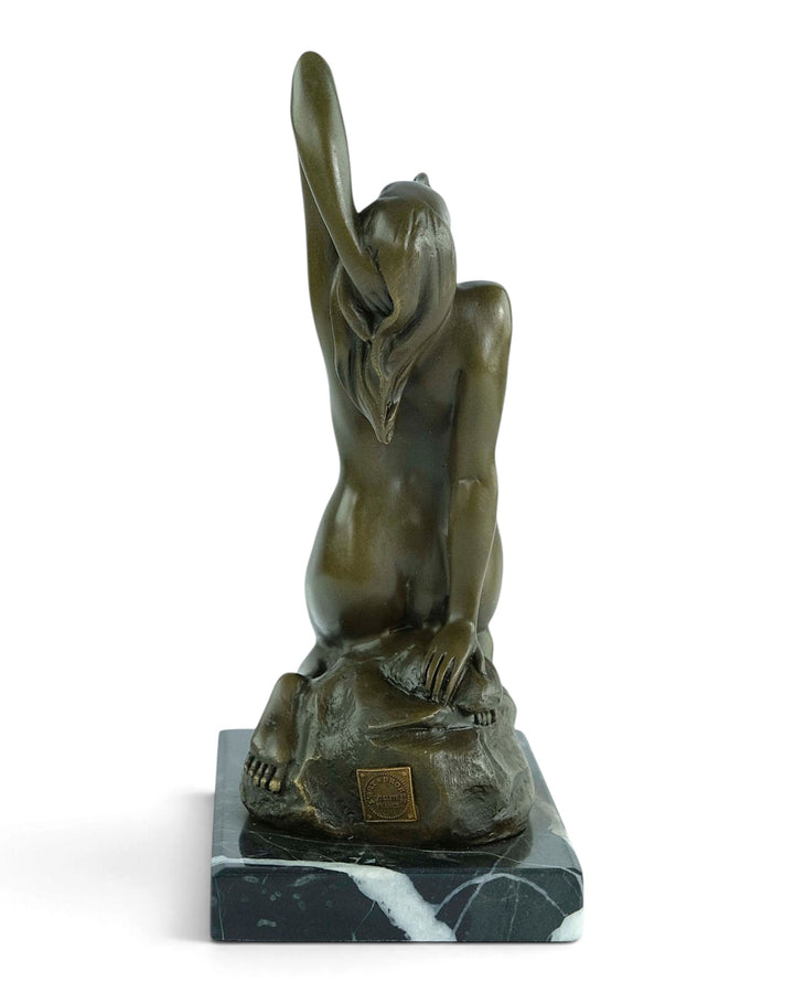 Bronzeskulptur eines sinnlichen weiblichen Aktes, der auf einem Felsen kniet