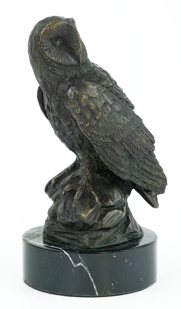 Bronze sculpture of an owl standing on a rock