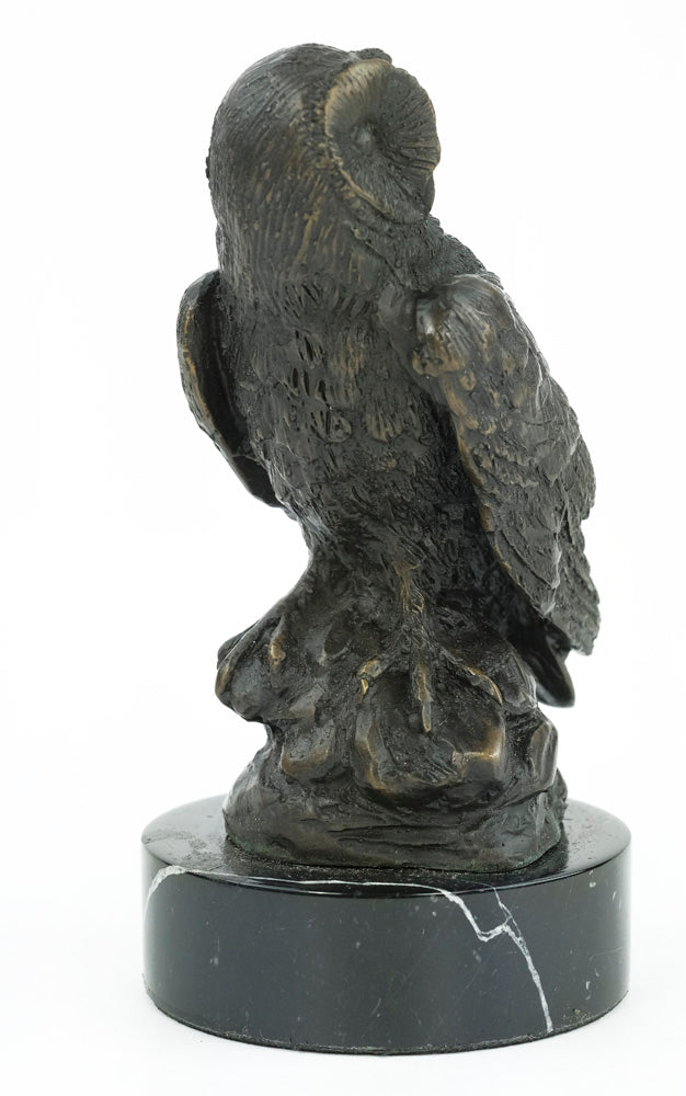 Bronze sculpture of an owl standing on a rock