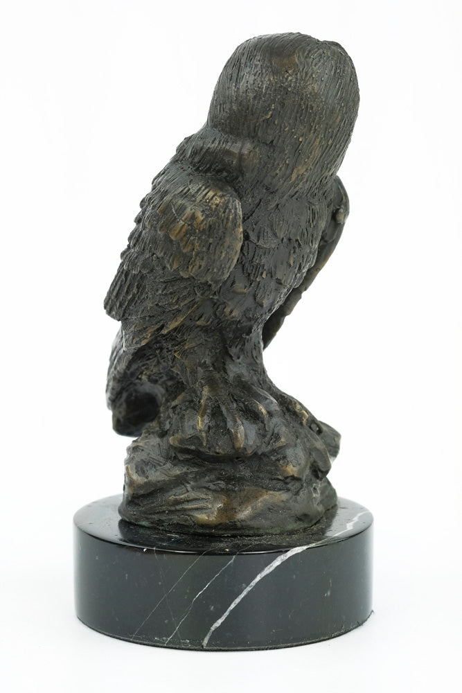 Bronze sculpture of an owl standing on a rock