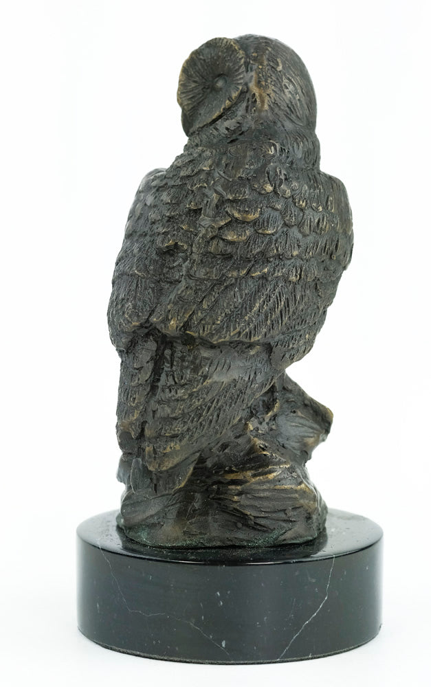 Bronze sculpture of an owl standing on a rock