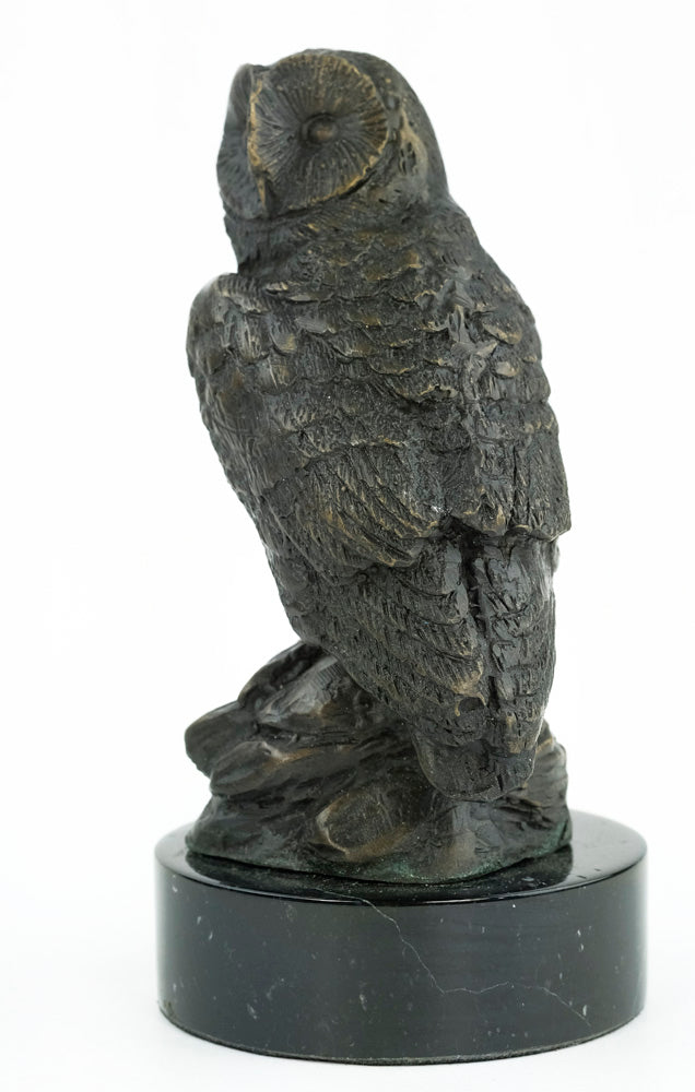Bronze sculpture of an owl standing on a rock