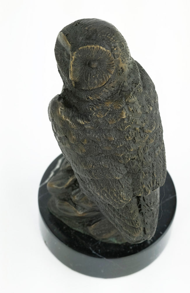 Bronze sculpture of an owl standing on a rock