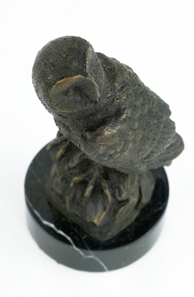 Bronze sculpture of an owl standing on a rock