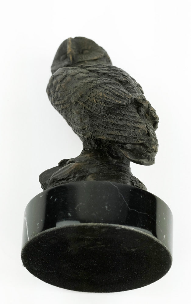 Bronze sculpture of an owl standing on a rock