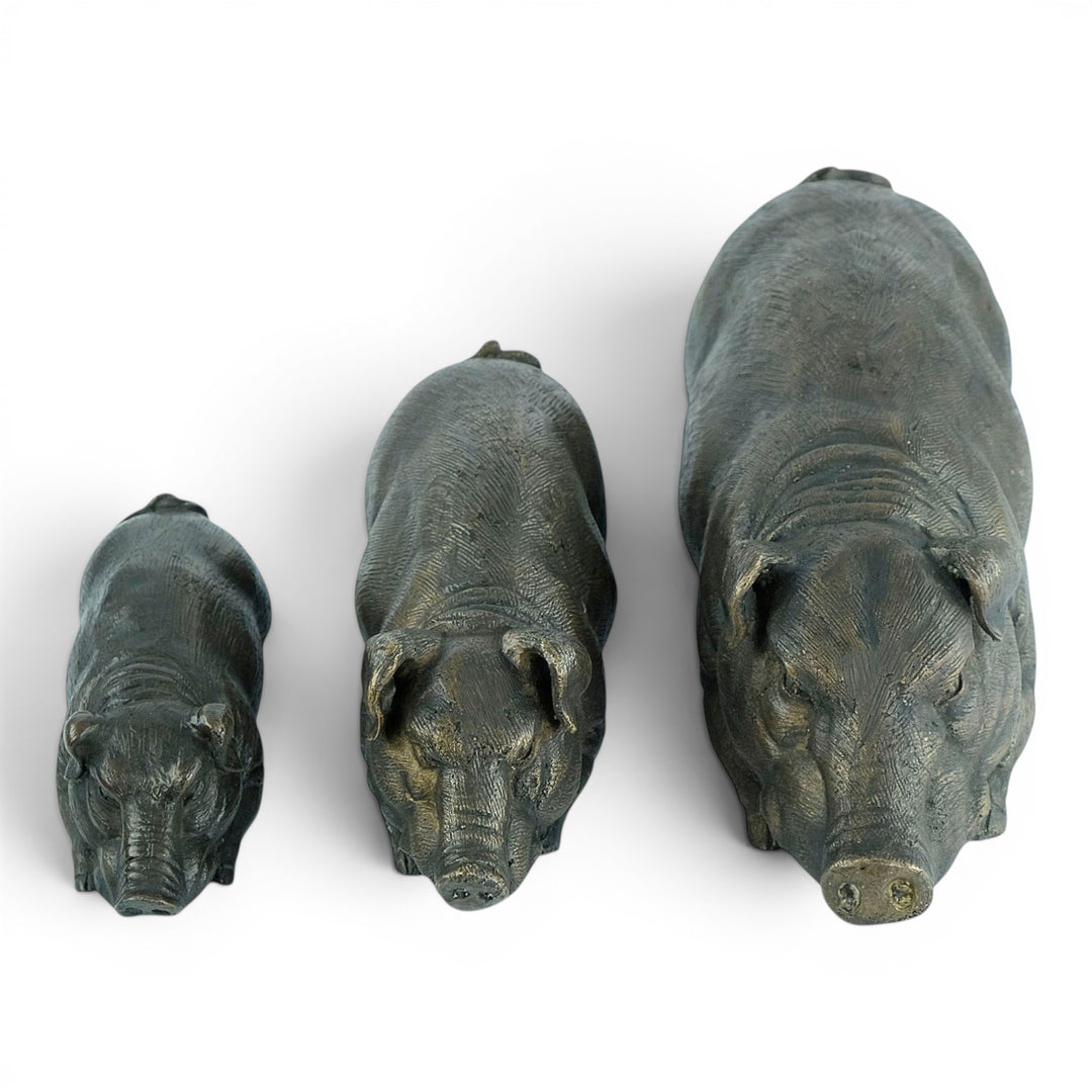 Conjunto de tres esculturas de cerdos tumbados en bronce