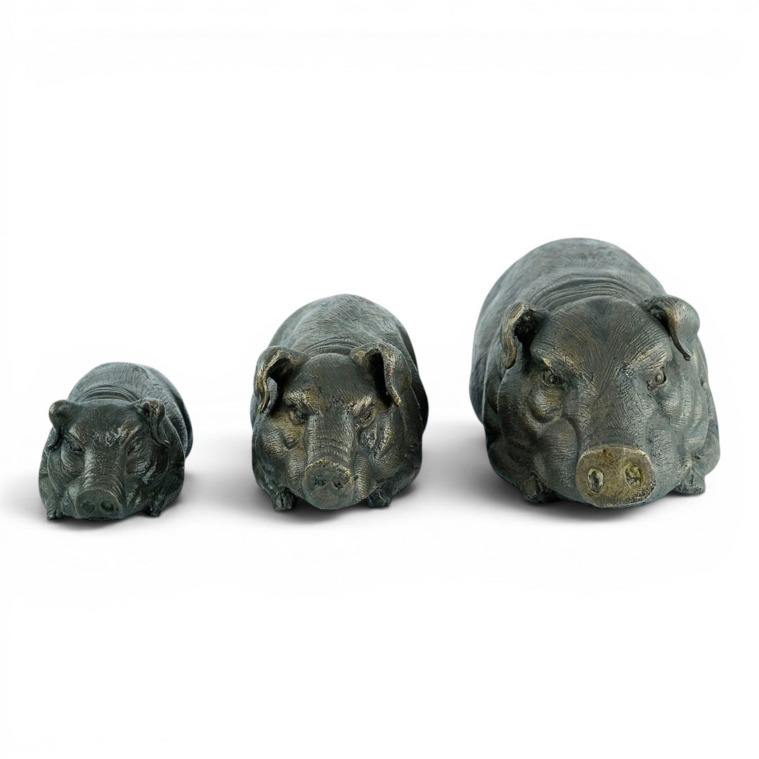 Conjunto de tres esculturas de cerdos tumbados en bronce