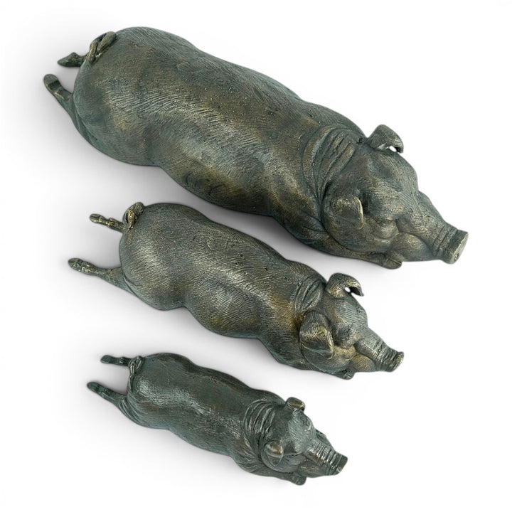 Conjunto de tres esculturas de cerdos tumbados en bronce