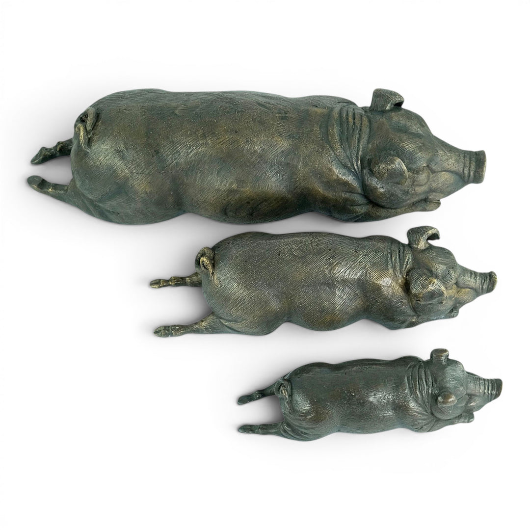 Conjunto de tres esculturas de cerdos tumbados en bronce