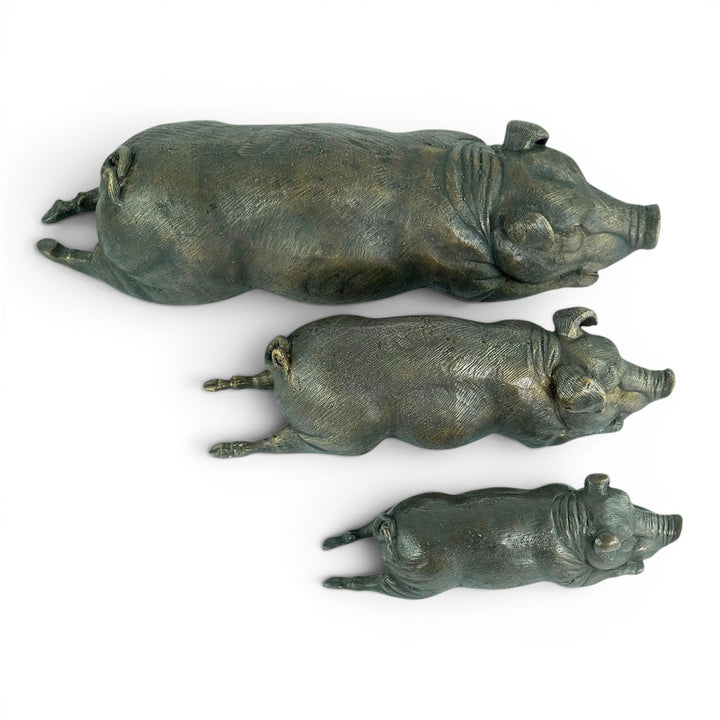 Conjunto de tres esculturas de cerdos tumbados en bronce