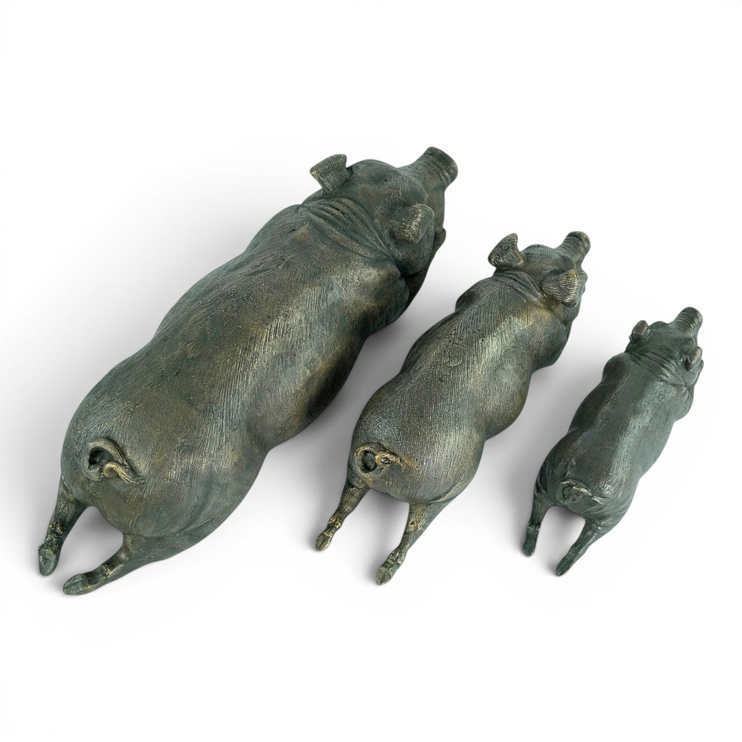 Conjunto de tres esculturas de cerdos tumbados en bronce