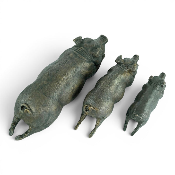 Conjunto de tres esculturas de cerdos tumbados en bronce