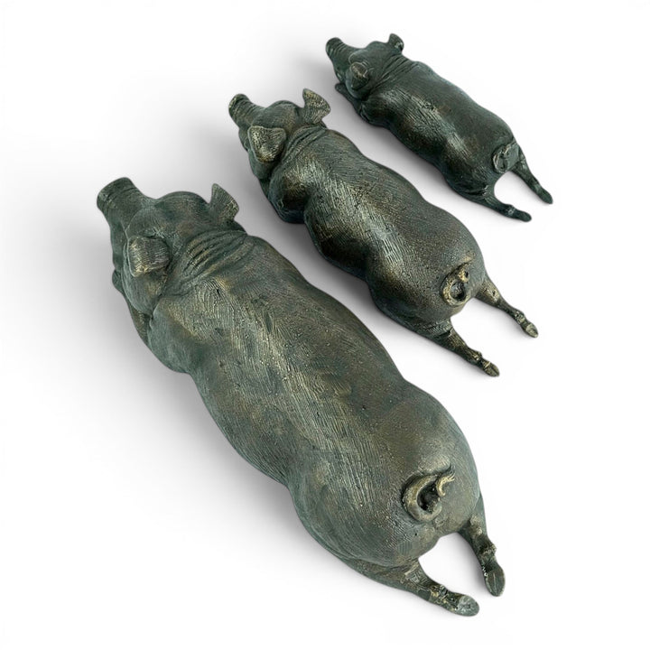 Conjunto de tres esculturas de cerdos tumbados en bronce