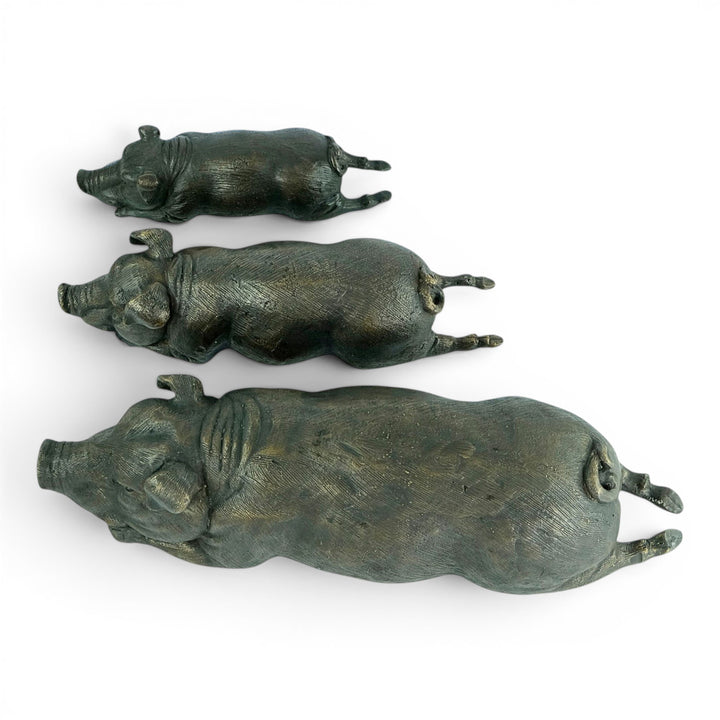 Conjunto de tres esculturas de cerdos tumbados en bronce