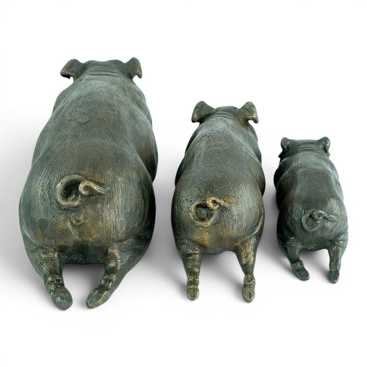 Conjunto de tres esculturas de cerdos tumbados en bronce