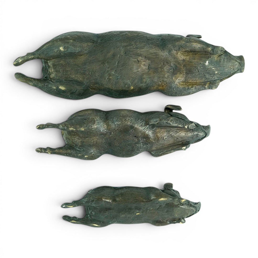 Conjunto de tres esculturas de cerdos tumbados en bronce