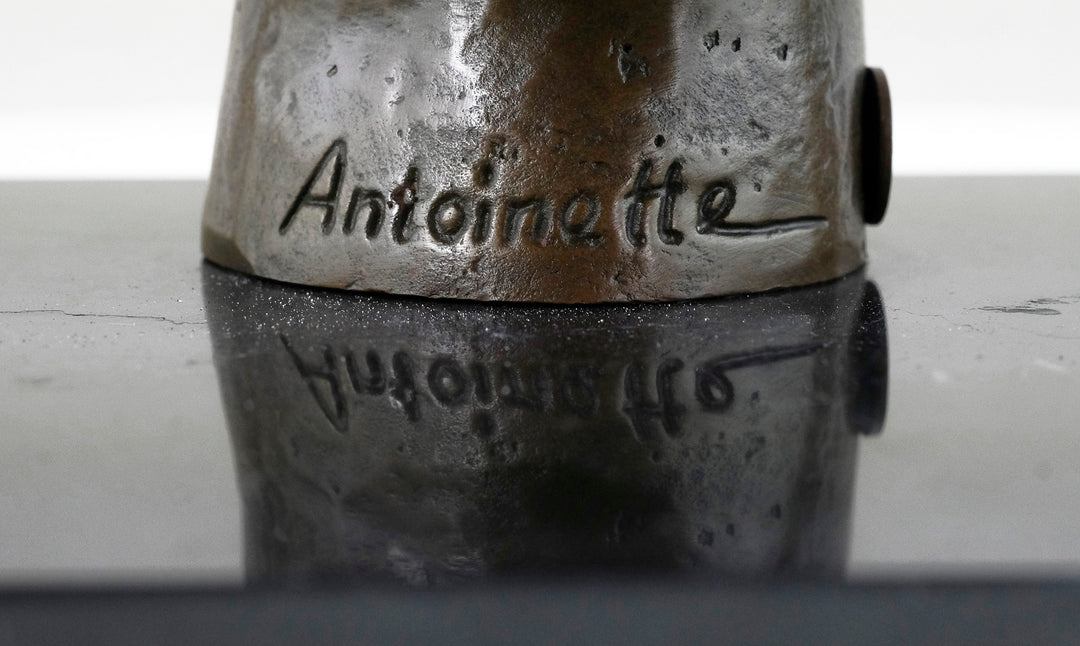 Escultura de bronce de un gato descansando en una mano