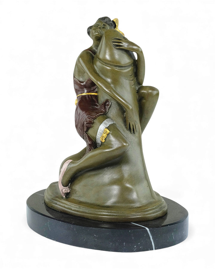 Escultura de bronce de una mujer abrazando un falo.