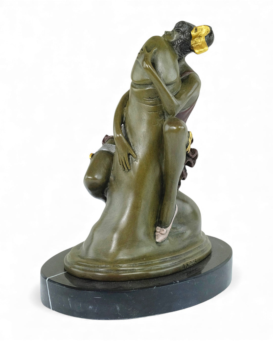 Escultura de bronce de una mujer abrazando un falo.