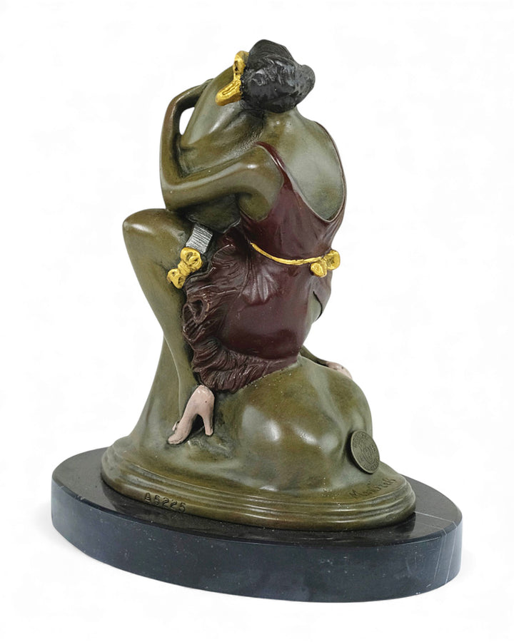 Escultura de bronce de una mujer abrazando un falo.