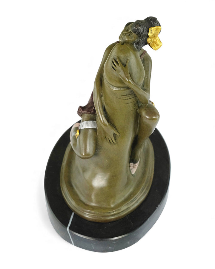 Escultura de bronce de una mujer abrazando un falo.