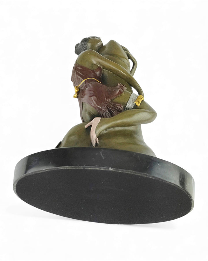 Escultura de bronce de una mujer abrazando un falo.