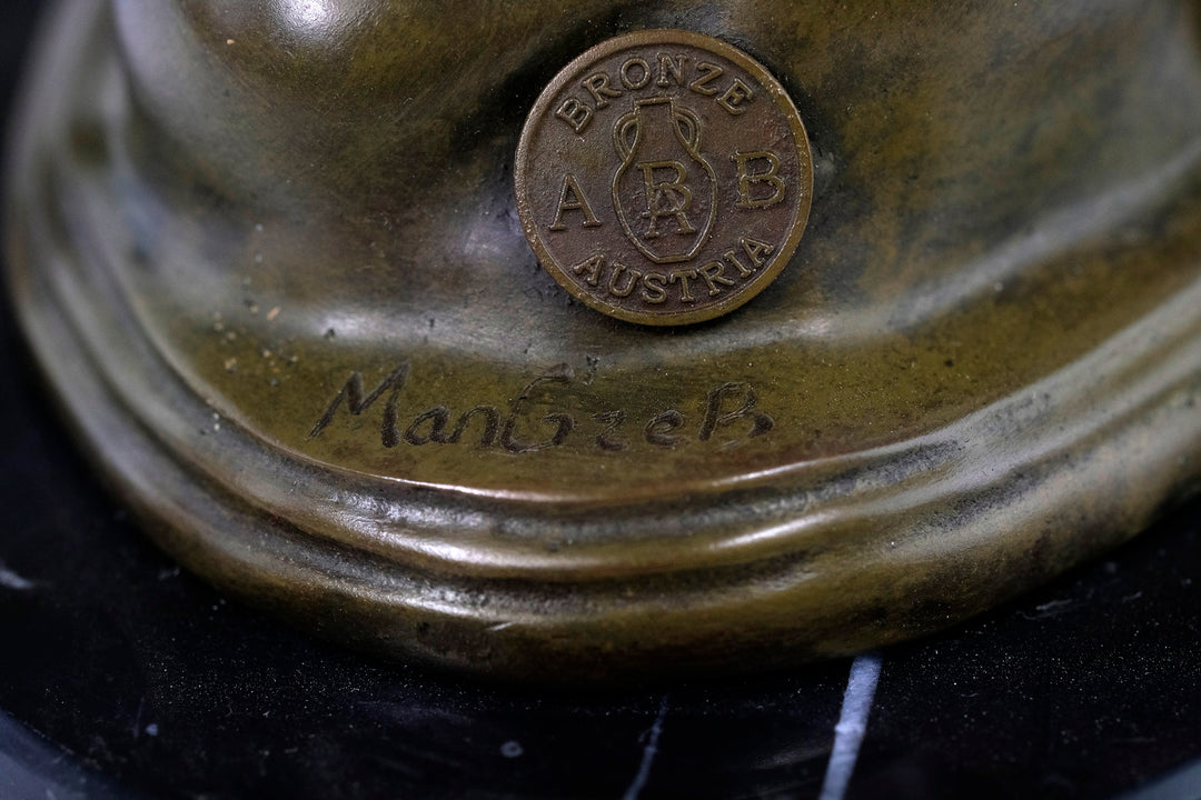 Escultura de bronce de una mujer abrazando un falo.