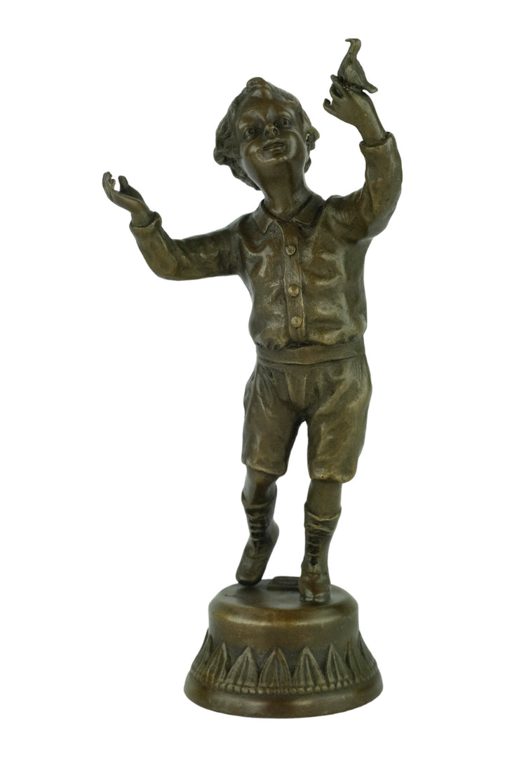Bronze sculpture of a young boy fascinated by a bird