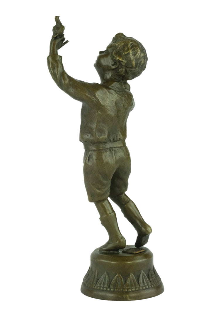 Bronze sculpture of a young boy fascinated by a bird