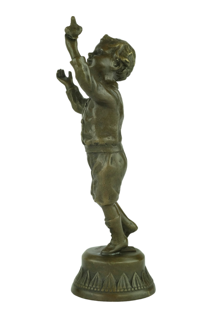 Bronze sculpture of a young boy fascinated by a bird