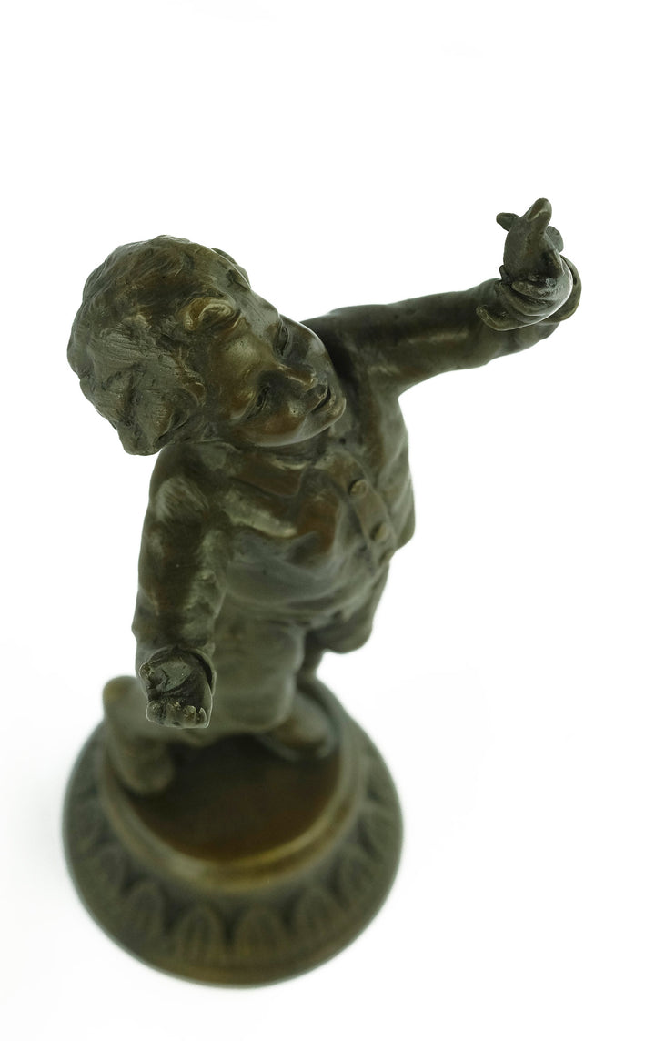 Bronze sculpture of a young boy fascinated by a bird