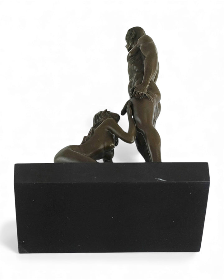 Escultura erótica de bronce de una mujer dando placer oral a un hombre