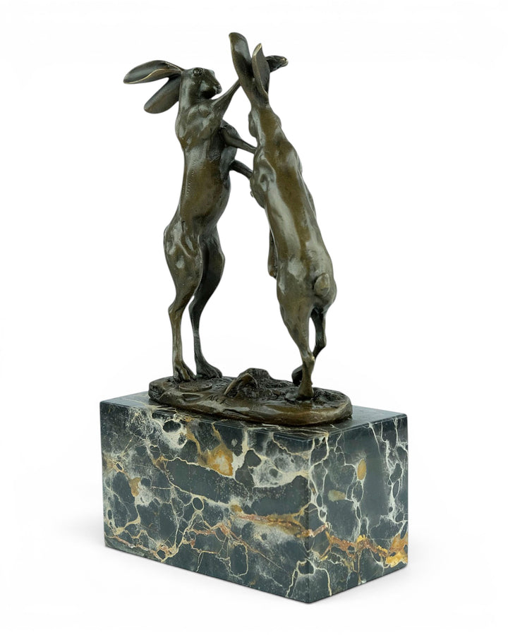 Escultura de bronce de dos liebres boxeadoras