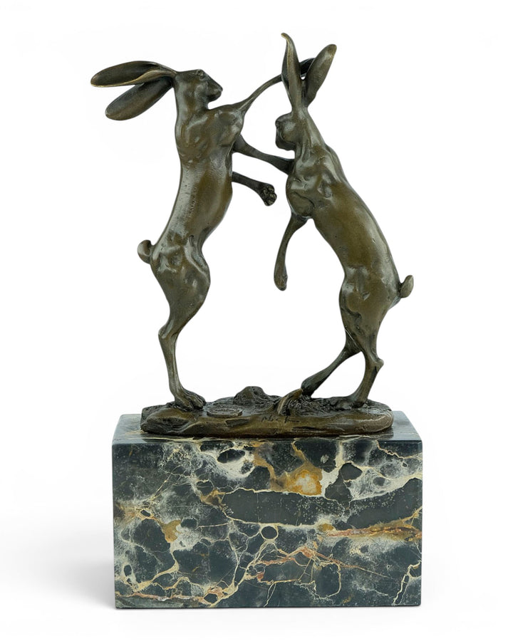 Escultura de bronce de dos liebres boxeadoras