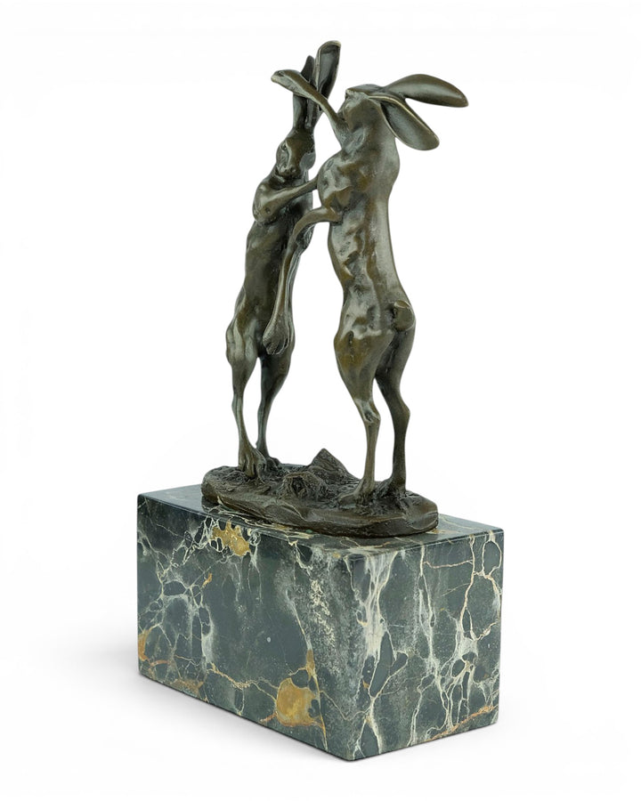 Escultura de bronce de dos liebres boxeadoras